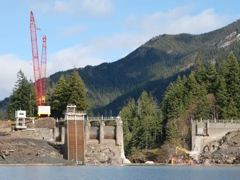 A crane stands on the half-demolished concrete of Glines Canyon Dam above the Elwha River.